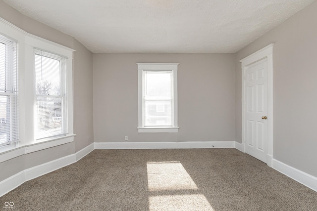 carpeted spare room with a textured ceiling