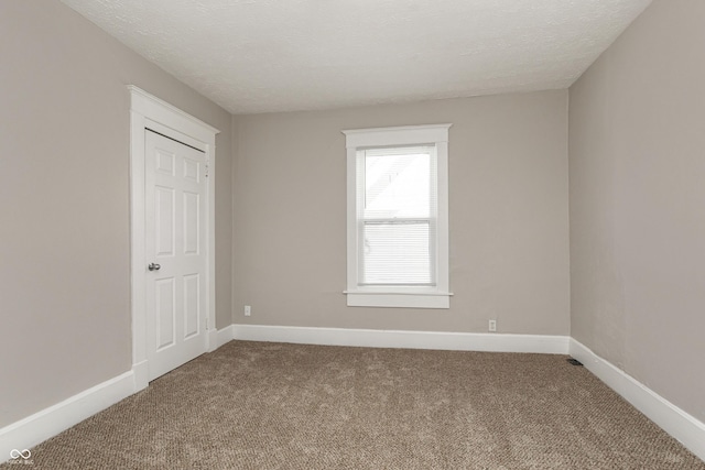 unfurnished room with carpet floors and a textured ceiling