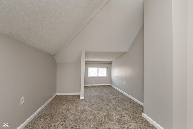 bonus room with vaulted ceiling, carpet, and a textured ceiling