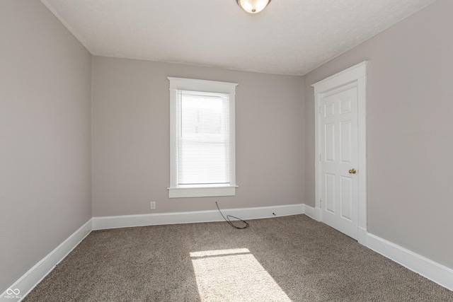 carpeted empty room with a textured ceiling