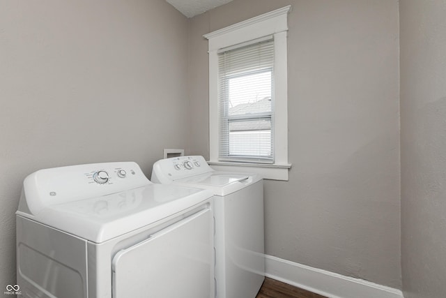 clothes washing area with dark hardwood / wood-style flooring and washing machine and dryer