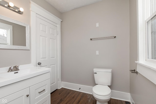 bathroom featuring vanity, a textured ceiling, toilet, and hardwood / wood-style flooring