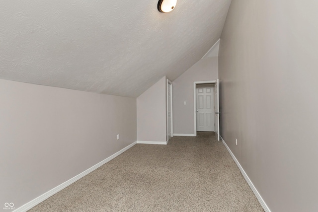 bonus room with lofted ceiling, a textured ceiling, and carpet flooring