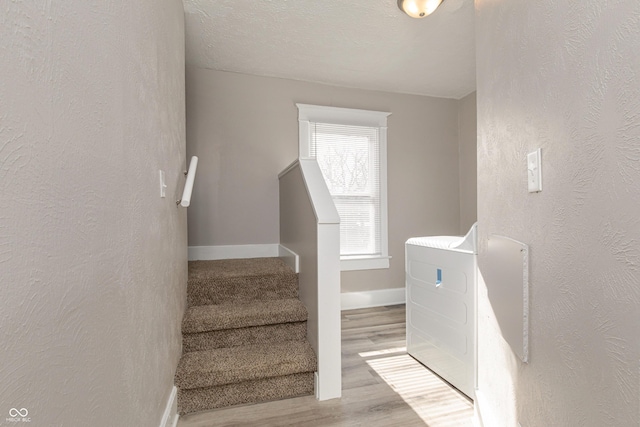 stairway featuring hardwood / wood-style flooring and washer / dryer