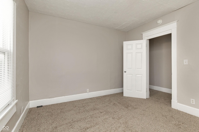 unfurnished bedroom featuring carpet and a textured ceiling