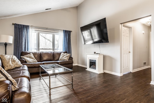 living room featuring dark hardwood / wood-style flooring and vaulted ceiling