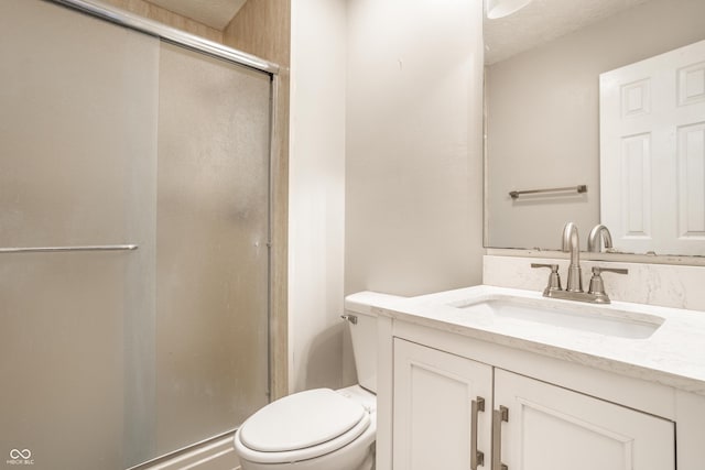 bathroom with vanity, toilet, and a shower with shower door