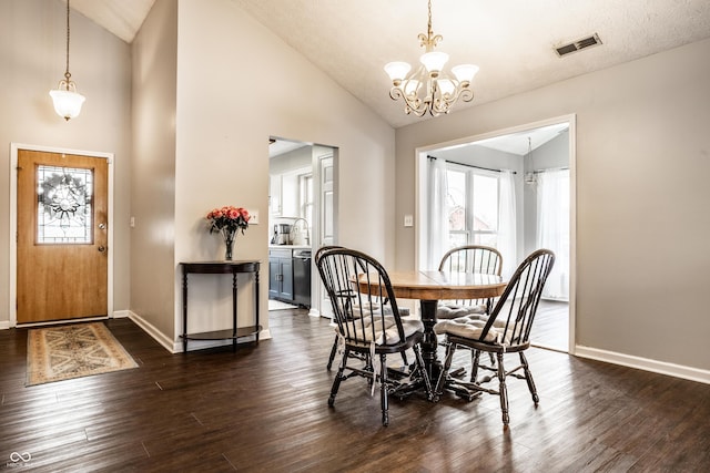 dining space featuring lofted ceiling, dark hardwood / wood-style floors, and a chandelier