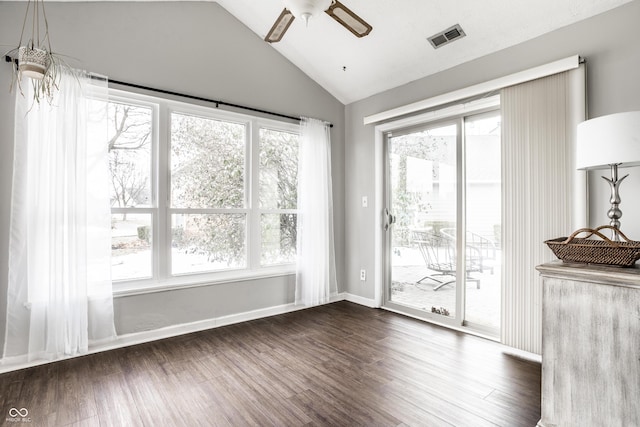 interior space with ceiling fan, lofted ceiling, plenty of natural light, and dark hardwood / wood-style flooring