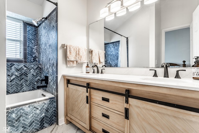 bathroom featuring tiled shower / bath and vanity