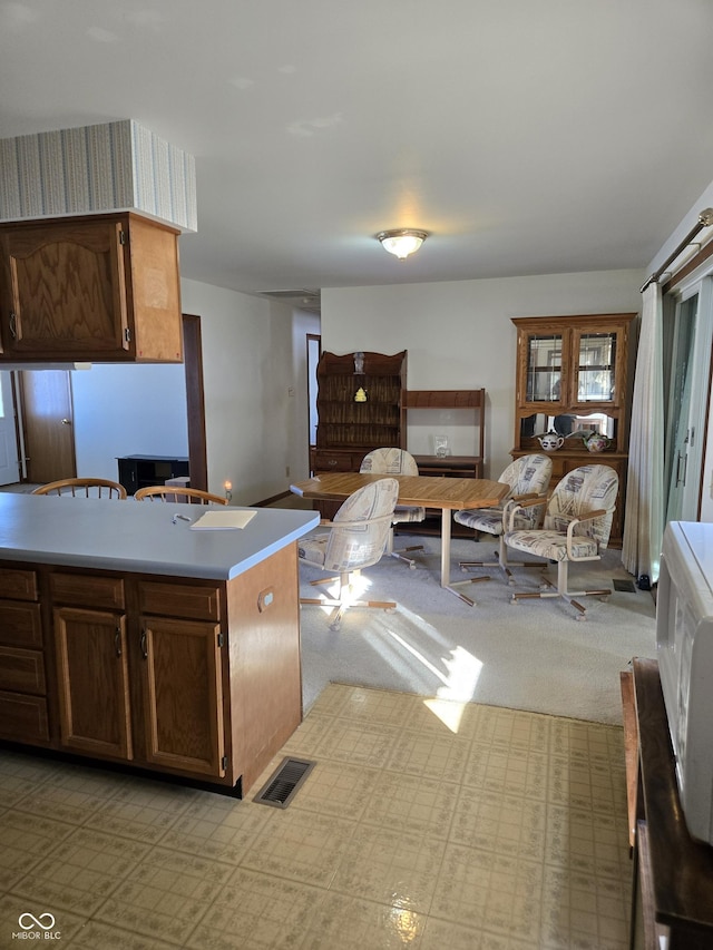 kitchen featuring a center island and light colored carpet