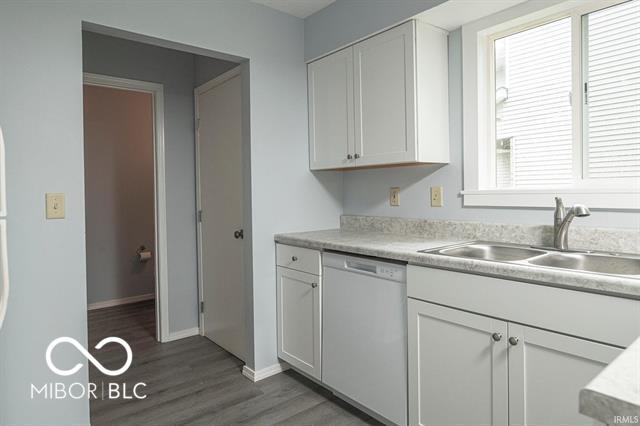 kitchen with sink, plenty of natural light, white cabinets, and dishwasher