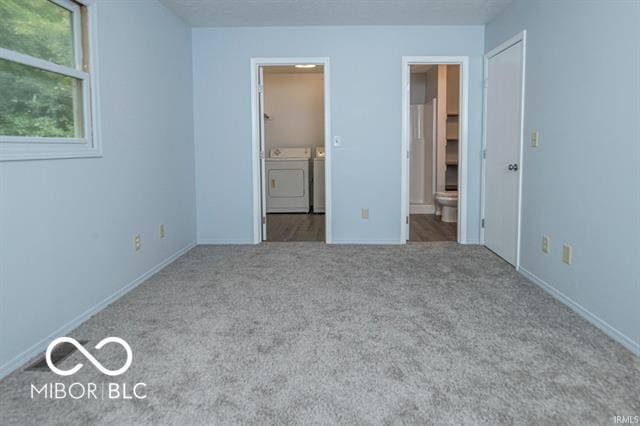 unfurnished bedroom with separate washer and dryer, connected bathroom, and light colored carpet