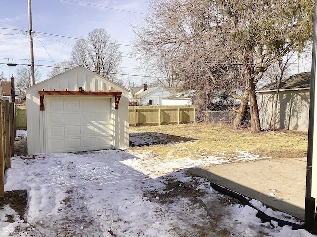 yard covered in snow with a garage and an outdoor structure