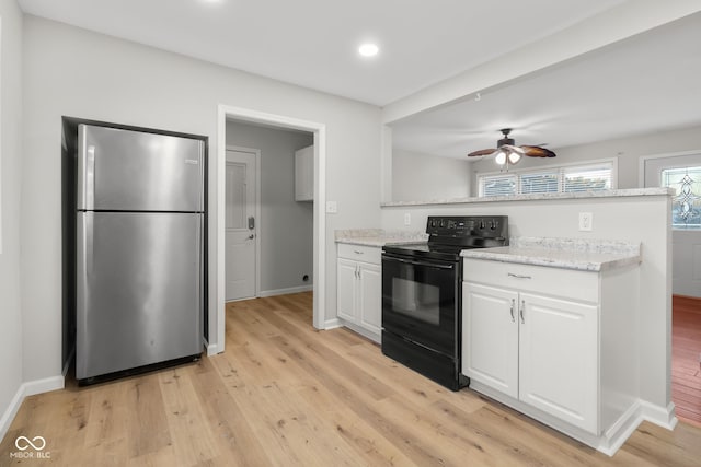 kitchen with stainless steel refrigerator, white cabinets, black range with electric cooktop, light stone countertops, and light hardwood / wood-style flooring