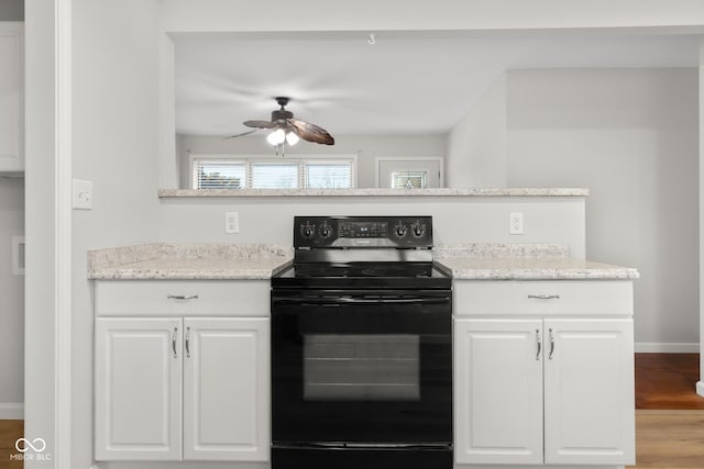 kitchen with black range with electric stovetop, light hardwood / wood-style flooring, white cabinets, and ceiling fan