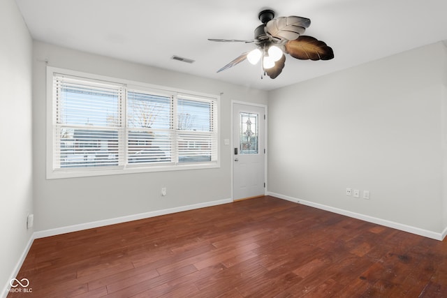 spare room featuring a wealth of natural light, dark hardwood / wood-style floors, and ceiling fan