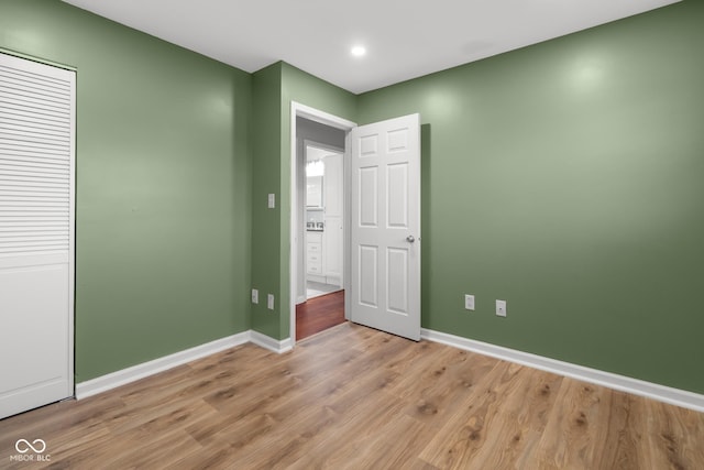 unfurnished bedroom featuring light hardwood / wood-style floors and a closet