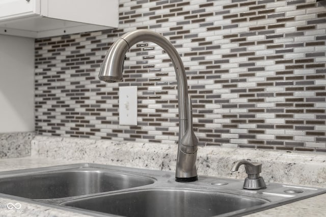 details with sink, decorative backsplash, and white cabinets