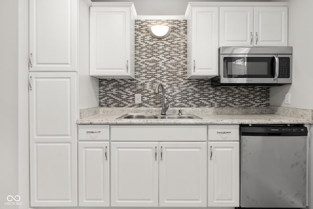 kitchen featuring backsplash, stainless steel appliances, sink, and white cabinets