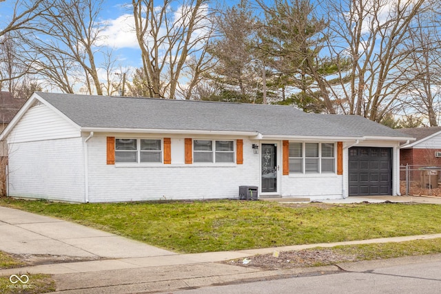 ranch-style house featuring a garage, central AC, and a front lawn