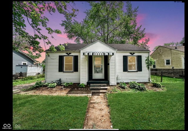 bungalow-style house featuring a lawn