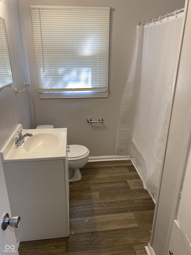 bathroom with vanity, hardwood / wood-style floors, curtained shower, and toilet