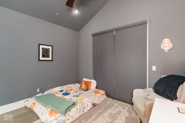 bedroom with lofted ceiling, light wood-type flooring, ceiling fan, and a closet