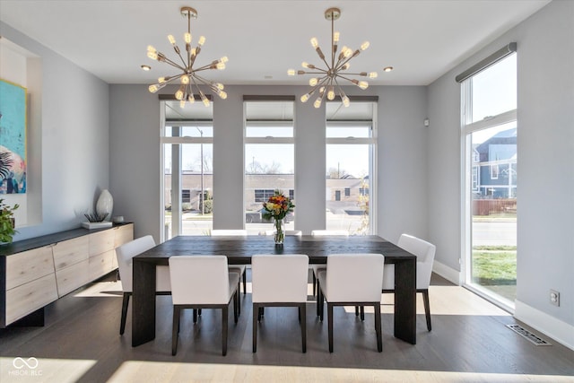 dining space with dark hardwood / wood-style floors and an inviting chandelier