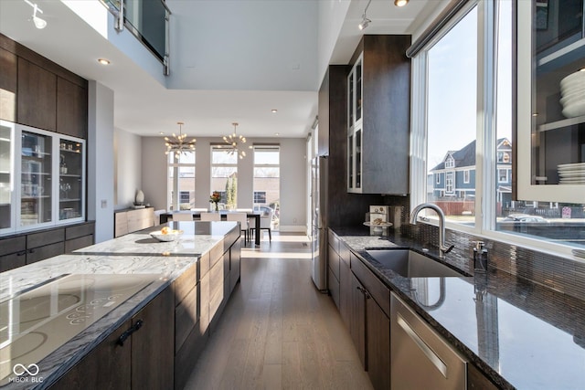 kitchen featuring sink, dark brown cabinets, dark stone countertops, dishwasher, and black electric stovetop