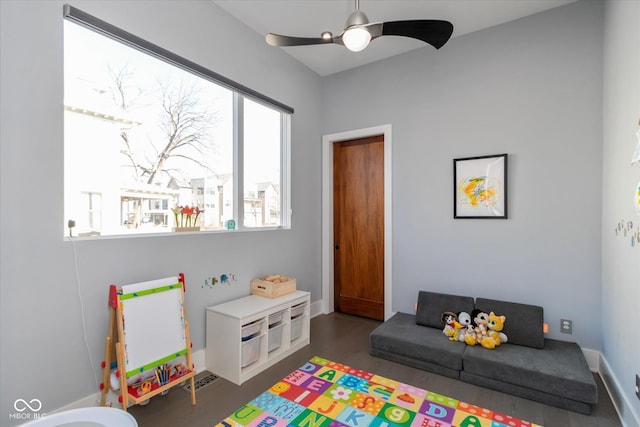 game room with dark wood-type flooring and ceiling fan