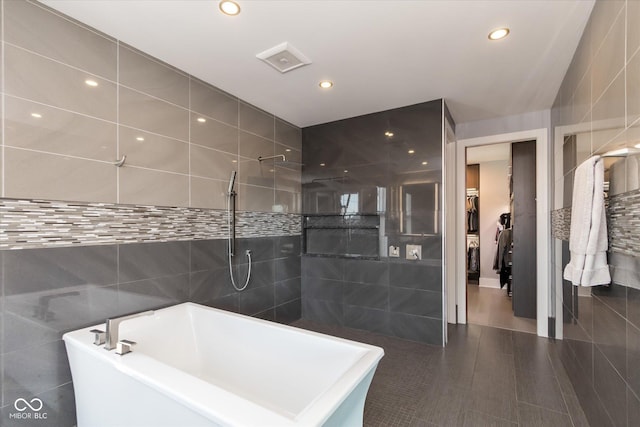 bathroom with independent shower and bath and tile walls