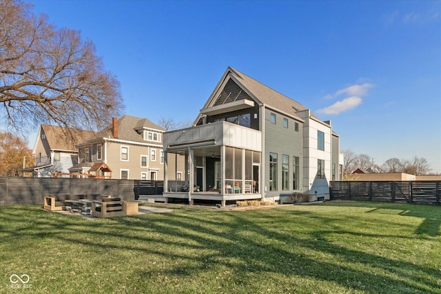 rear view of property with a wooden deck, a sunroom, and a yard