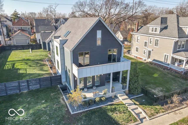 rear view of property featuring a yard, a patio, and a balcony