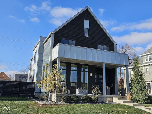 view of front of property featuring a front yard, a balcony, and covered porch