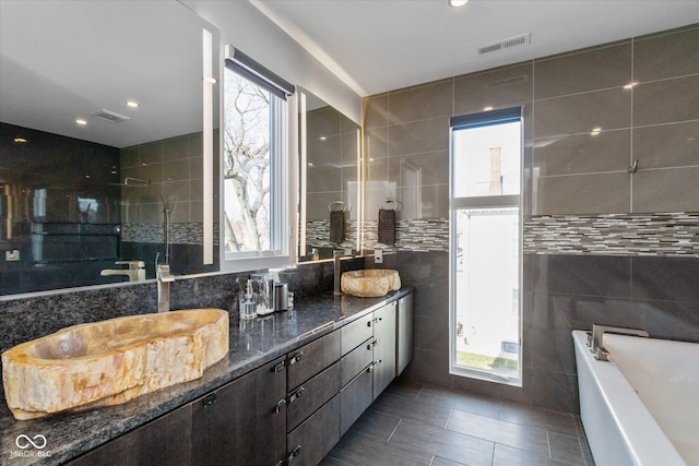 bathroom featuring a wealth of natural light, tile walls, vanity, and tile patterned floors