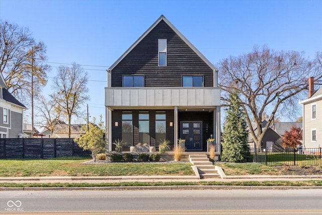 view of front of property with a porch, a balcony, and a front lawn