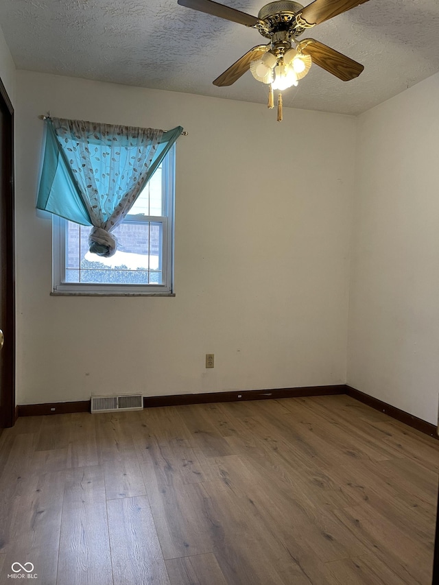 spare room with ceiling fan, hardwood / wood-style floors, and a textured ceiling