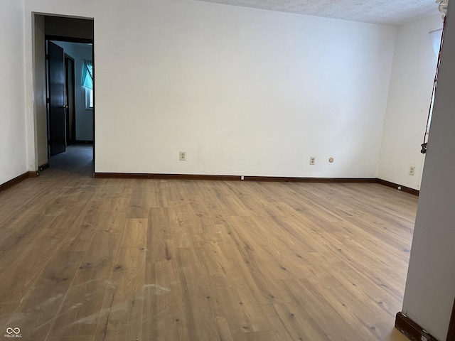 unfurnished room featuring light hardwood / wood-style flooring and a textured ceiling