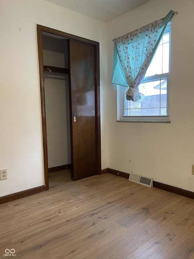 unfurnished bedroom featuring a closet and light wood-type flooring