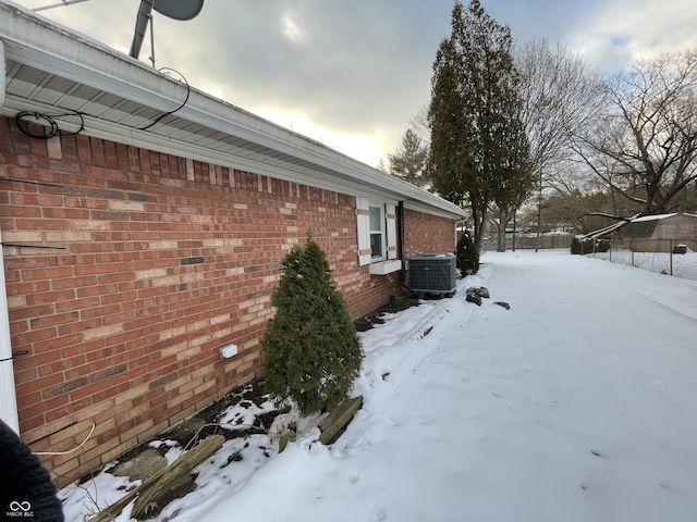 view of snowy exterior with central AC