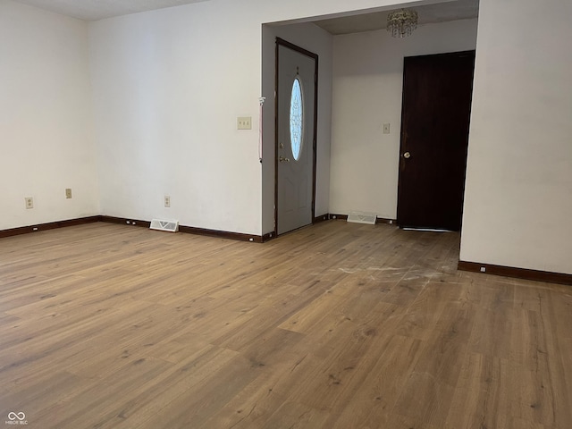 entryway featuring hardwood / wood-style flooring and a notable chandelier