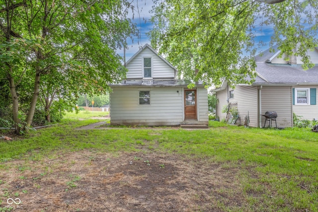 rear view of property featuring a yard