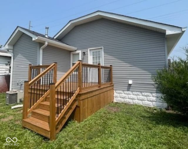 rear view of house with central air condition unit, a yard, and a deck