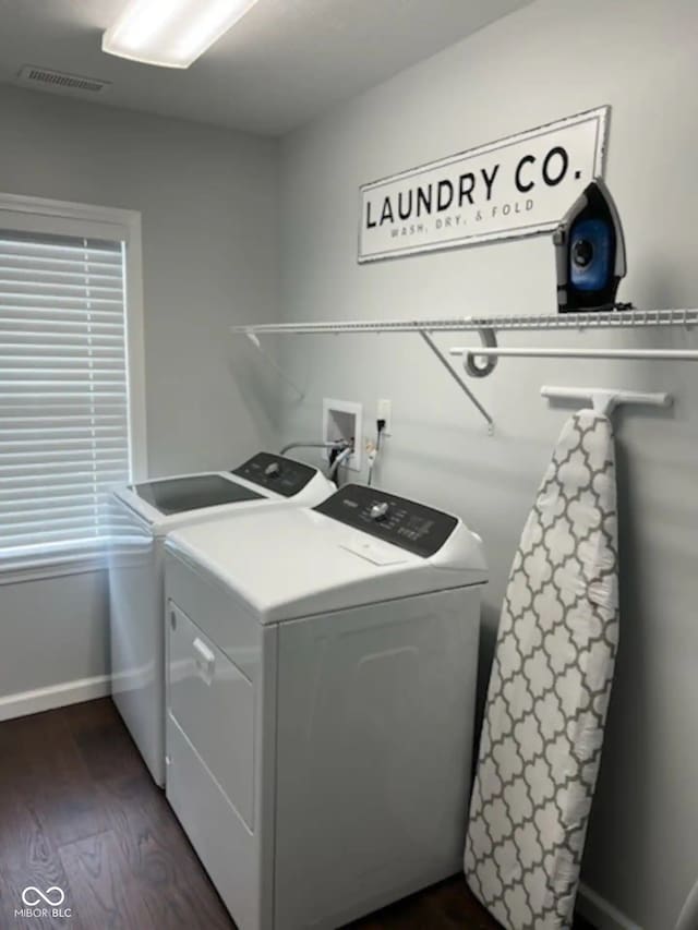 washroom with visible vents, dark wood-type flooring, baseboards, laundry area, and separate washer and dryer