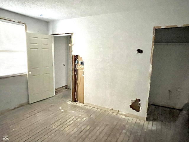 unfurnished room featuring hardwood / wood-style flooring and a textured ceiling