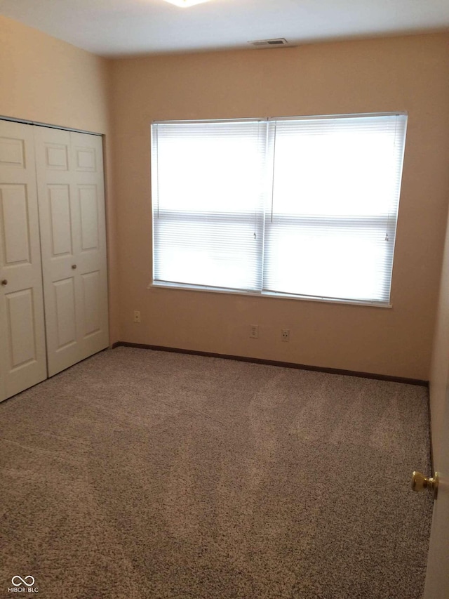 unfurnished bedroom with carpet floors and a closet