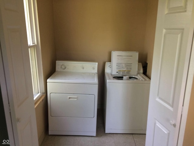 washroom featuring light tile patterned floors, plenty of natural light, and washer and dryer