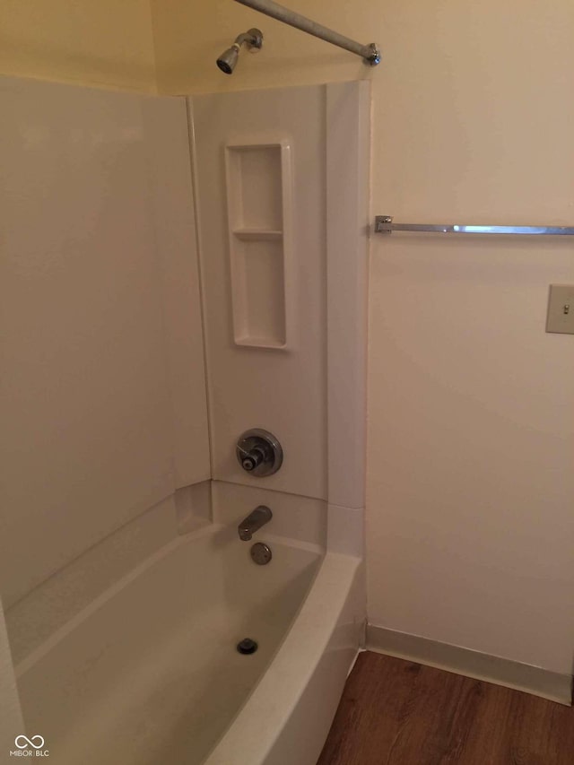 bathroom with hardwood / wood-style flooring and shower / washtub combination