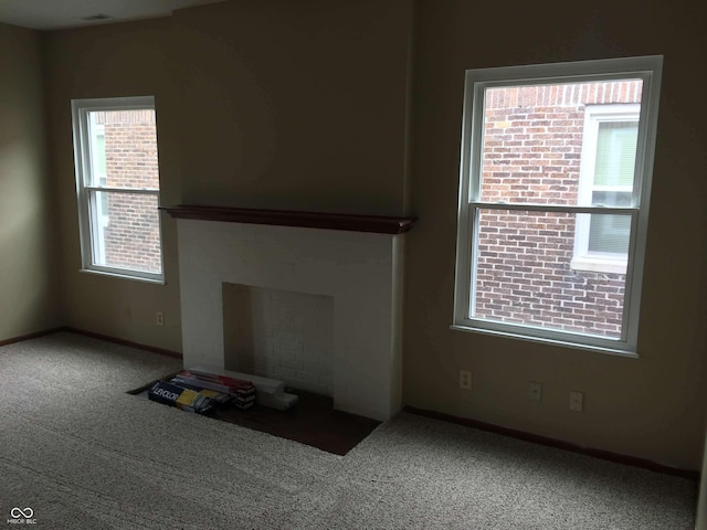 unfurnished living room featuring a fireplace and carpet